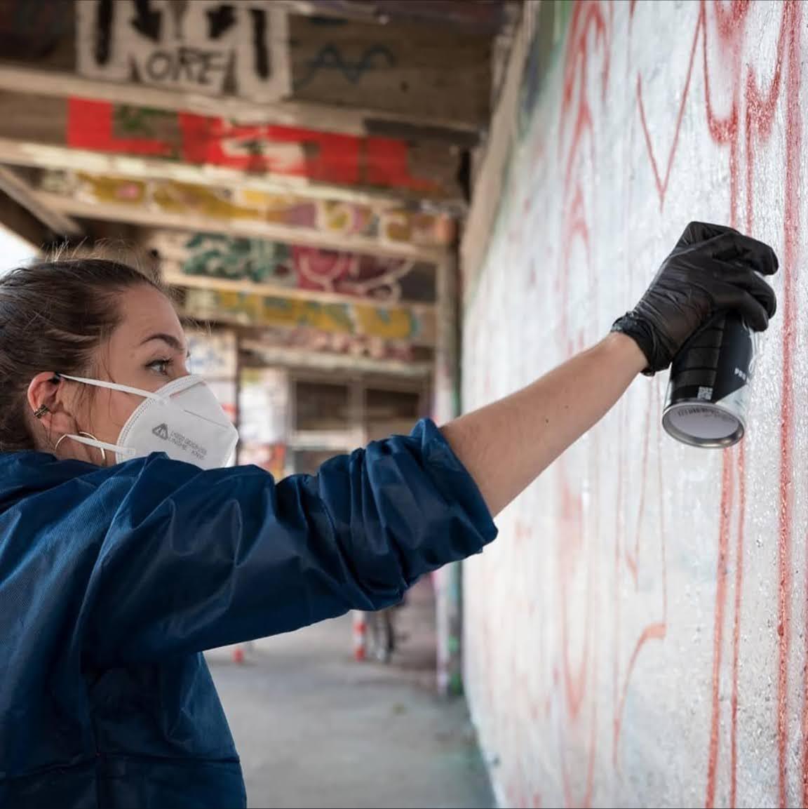 Jona spraying on a legal graffiti wall